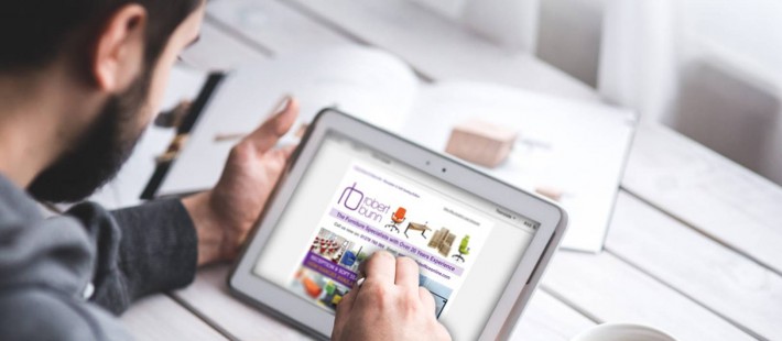 man using tablet on white wooden table